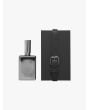 Front view of the silver-tone glass bottle of Goti White perfume and black box with strap.